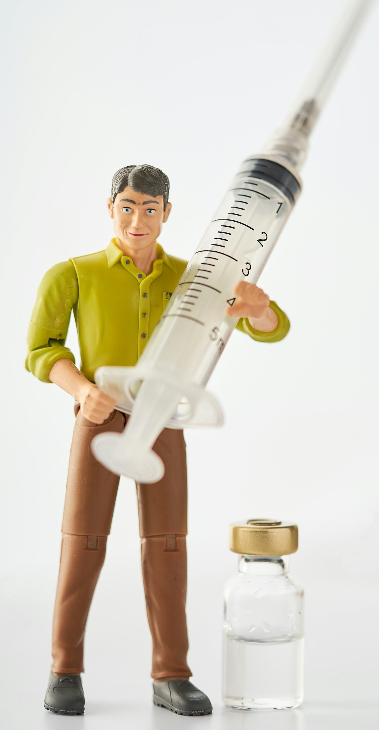 a toy man holding a syquet next to a bottle of medicine